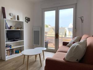 een woonkamer met een bank en een tafel bij Appartement à 200m de la mer à TREGASTEL PLAGES - Réf 744 in Trégastel