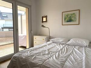 een wit bed in een slaapkamer met een raam bij Appartement à 200m de la mer à TREGASTEL PLAGES - Réf 744 in Trégastel