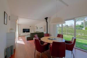 ユリアーナドルプにあるVakantiehuis Springtij met privé zwembad - Julianadorp aan Zeeのリビングルーム(テーブル、赤い椅子付) +25枚の写真