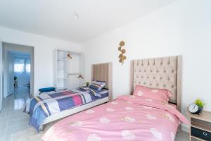 2 Betten in einem Schlafzimmer mit rosa Bettwäsche in der Unterkunft Les 3 Lys - Bel appartement 3 Chambres in Sevran