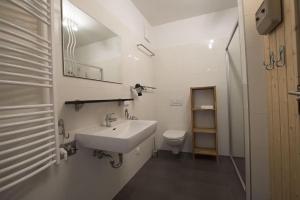 a white bathroom with a sink and a toilet at Haus CKPK Lux in Sonnenalpe Nassfeld +85 photos