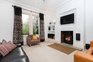 a living room with a fireplace and a tv at Thrushley Cottage in Wakefield - sleeps 7 - with roof terrace 