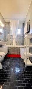 uma casa de banho com piso em azulejo preto e uma janela em Aparta hotel DAJAS em Lausana