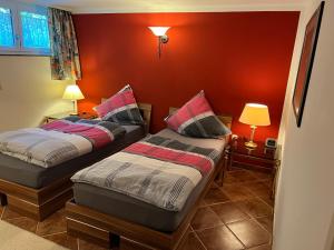 two beds in a room with red walls at 3 separate Messe Appartements bis zu 11 Personen in Ratingen