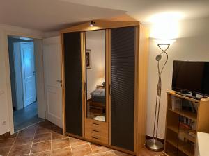 Cette chambre comprend un placard avec un miroir et une lampe. dans l'établissement 3 separate Messe Appartements bis zu 11 Personen, à Ratingen