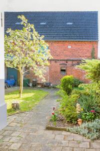 a garden with a tree and a brick building at "Dornröschen" in Bad Wilsnack