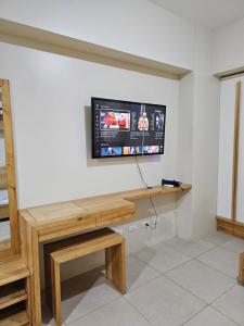 une télévision sur un mur avec un bureau en bois dans l'établissement Best inn CEBU Avida Riala Tower 2 716, à Cebu