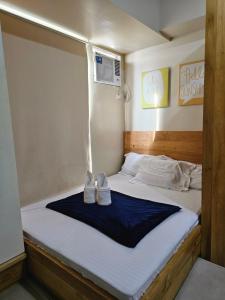 un lit avec des chaussures blanches assises au-dessus dans l'établissement Best inn CEBU Avida Riala Tower 2 716, à Cebu 29 autres photos
