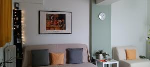 een woonkamer met een bank en een foto aan de muur bij Athenian Asty Guesthouse in Athene