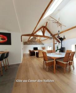 Au Cœur des Vallées في كوفين: غرفة طعام وغرفة معيشة مع طاولة وكراسي