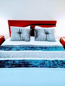 a bed with blue and white sheets and pillows at Porto Cruz in Vila Nova de Gaia