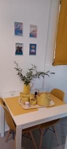 a table with yellow dishes and a vase on it at Athenian Asty Guesthouse in Athens