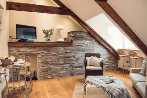 a living room with a stone wall at Duke House - Top Floor Apartment - 1 bedroom apartment with Hot Tub in Padstow