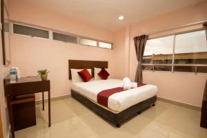 a bedroom with a bed and a desk and a window at Sun Inns Hotel Bestari Jaya in Batang Berjuntai