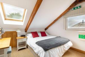 a bedroom with a bed and a desk and a window at Duke House - Top Floor Apartment - 1 bedroom apartment with Hot Tub in Padstow