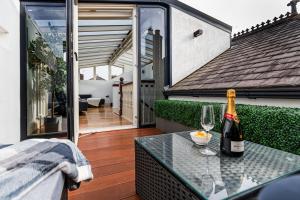 uma garrafa de vinho sentada numa mesa na varanda em Thrushley Cottage in Wakefield - sleeps 7 - with roof terrace 