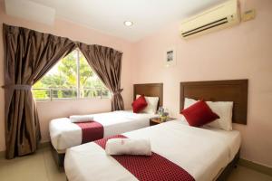 Habitación de hotel con 2 camas y ventana en Sun Inns Hotel Bestari Jaya, en Batang Berjuntai