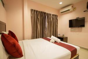 ein Hotelzimmer mit einem Bett und einem TV in der Unterkunft Sun Inns Hotel Bestari Jaya in Batang Berjuntai