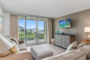 a living room with a couch and a tv at Updated 2 Bed Condo Offering Long Beach Views From Balcony in Marco Island