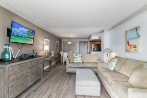 a living room with a couch and a table at Updated 2 Bed Condo Offering Long Beach Views From Balcony in Marco Island