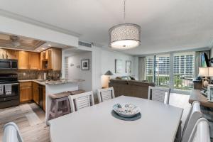 a kitchen and dining room with a white table and chairs at Updated 2 Bed Condo Offering Long Beach Views From Balcony in Marco Island