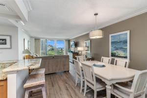 a dining room and living room with a table and chairs at Updated 2 Bed Condo Offering Long Beach Views From Balcony in Marco Island
