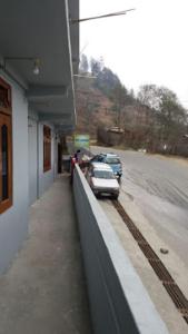 ein Auto, das vor einem Gebäude neben einer Straße geparkt ist, in der Unterkunft HOTEL DENGCHEM Bomdila in Bomdila