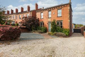 a brick house with a driveway in front of it at Thrushley Cottage in Wakefield - sleeps 7 - with roof terrace 