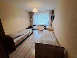 a room with two beds and a window at Jaukus butas in Klaipėda