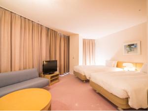 a hotel room with two beds and a tv at Naeba Prince Hotel in Yuzawa