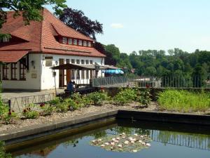 una casa con un estanque con lirios en el patio en Herberge Burg Hohnstein, en Hohnstein