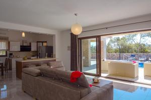 a living room with a couch and a kitchen at Modern villa with pool, sea view, near the sea and the beach - by Traveler tourist agency Krk ID 2168 in Pinezici