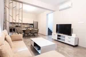 Una sala de estar con un sofá y un televisor. en Luxury Panorama Villa Protaras, en Protaras