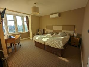Schlafzimmer mit einem Bett, einem Schreibtisch und einem Fenster in der Unterkunft The Seal in Selsey