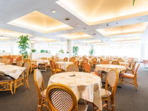 ein Speisesaal voller Tische und Stühle mit weißen in der Unterkunft Naeba Prince Hotel in Yuzawa