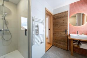 La salle de bains est pourvue d'une douche et d'un lavabo. dans l'établissement PAPILL'ON - Boutique Hotel, à La Tzoumaz