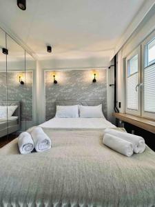 - une chambre avec un grand lit et des serviettes dans l'établissement Apartament Augustiańska, à Cracovie