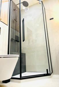 La salle de bains est pourvue d'une douche avec une porte en verre. dans l'établissement Apartament Augustiańska, à Cracovie