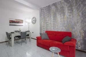 sala de estar con sofá rojo y mesa en Lago di Lecco - Parcheggio Gratuito - Stazione Ferroviaria, en Calolziocorte