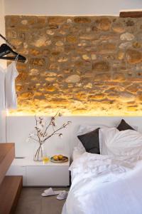 a bedroom with a stone wall above a bed at Salvadonica in San Casciano in Val di Pesa