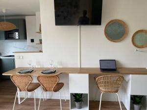 eine Küche mit einem Tisch mit Stühlen und einem Laptop darauf in der Unterkunft Appart Hôtel Lison - rénové 2023 Vieux Lille in Lille