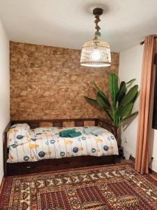 1 dormitorio con cama y pared de ladrillo en Naturaleza viva, en San Martín de Valdeiglesias