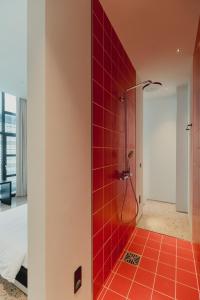 a bathroom with a shower with red tiles at Plexi Space in Athens