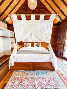 a bedroom with a bed with a mosquito net at Kayu Mama Resort and Spa in Uluwatu