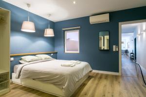 - une chambre avec des murs bleus et un lit avec des draps blancs dans l'établissement Cozy apartment in Amazing Location!, à Lisbonne