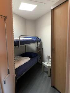 Cette chambre comprend 2 lits superposés et une porte. dans l'établissement Liguster 69*, à Nieuwvliet