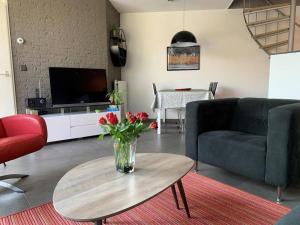 uma sala de estar com um vaso de flores sobre uma mesa em Liguster 69* em Nieuwvliet