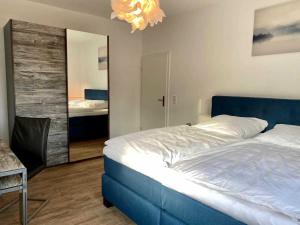 ein Schlafzimmer mit einem blauen Bett und einem Spiegel in der Unterkunft FeWoWa - FerienWohnungen Walter in Bad Sachsa