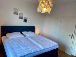 Bett in einem Schlafzimmer mit blauer Tagesdecke in der Unterkunft FeWoWa - FerienWohnungen Walter in Bad Sachsa