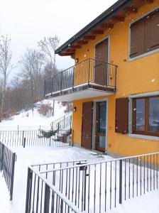 フィウマルボにあるCasa vacanza Doganaの雪の中のバルコニー付きの家